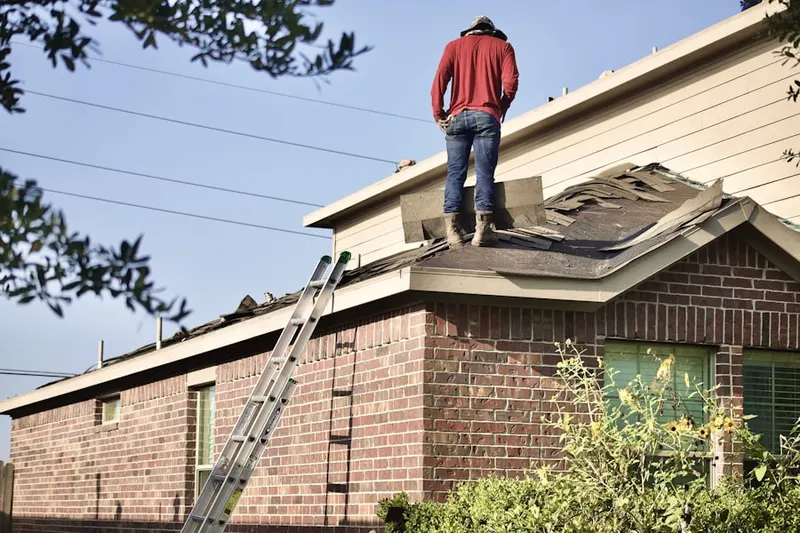 Professional roofer working on a residential roof in Altman